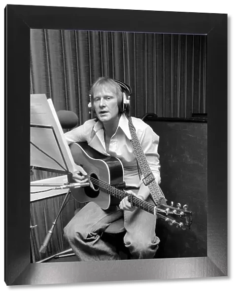 Actor Dennis Waterman, seen here in the recording studio with his guitar. December 1975