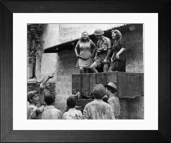 Framed Print : A British soldier helping the local villagers with the winepress after the Allied army