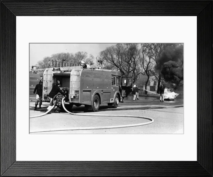 Framed Print : Firefighters in the latest fire engine fight to get a blaze under control