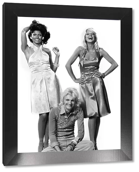 Brent Sherwood sandwiched between two of his kind of dresses in his kind of colours