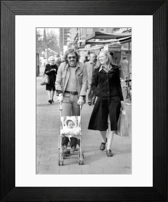 Framed Print : Mother and father pushing their little daughter along in a bugg on the streets of Framed Print : Mother and father pushing their little daughter along in a bugg on the streets of