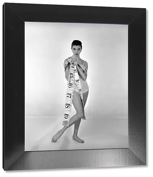 Model Gay Protheroe with outsize tape-measure. December 1956