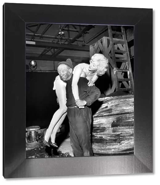 Actor Sidney James carrying Liz Fraser on set at Twickenham Studios were they are making