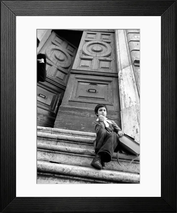 Framed Print : Young child sitting on the steps of an old building in a poor suburb on the outskirts of Framed Print : Young child sitting on the steps of an old building in a poor suburb on the outskirts of