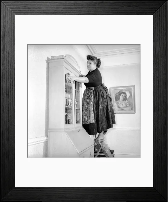Framed Print : Domestic Life: Woman (Mrs. Olive Haugh) dusting the bookcase: Circa 1954 Framed Print : Domestic Life: Woman (Mrs. Olive Haugh) dusting the bookcase: Circa 1954