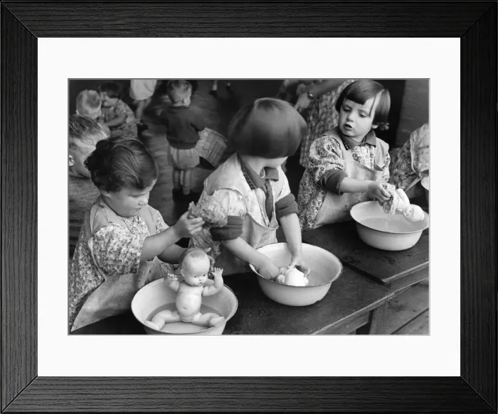 Framed Print : Children washing their dolls in a small tin bath during a nursery class in Northfields