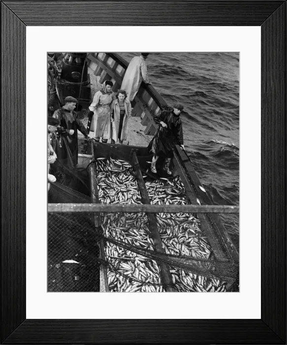 Framed Print : Freda Peterson, aged 20, (left) and Peggy Mckay, 17, watch their work piling up