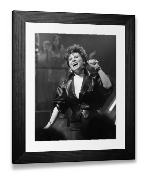 Framed Print : Singer Lulu dressed in leather jacket with microphone, on stage singing