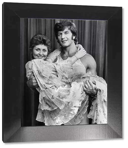 Lulu being lifted and cuddled by the arms of Strong Man Dave Prowse. October 1973 P035537