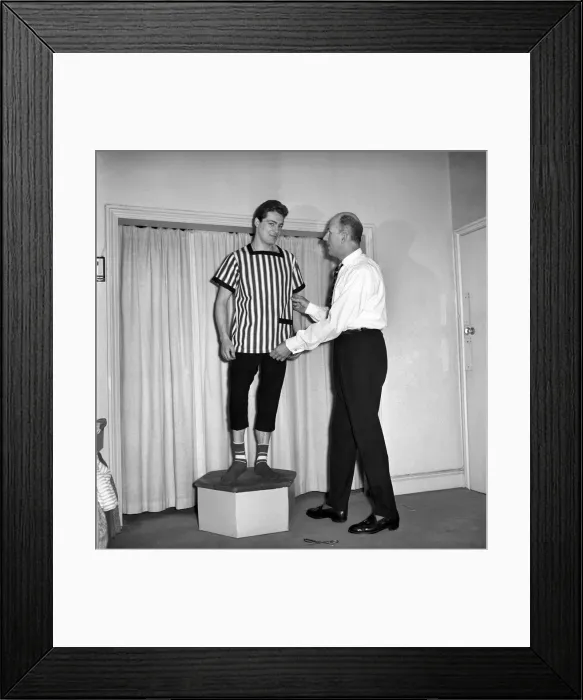 Framed Print : Mens Fashions: Tailor measuring and sewing in his workshop Framed Print : Mens Fashions: Tailor measuring and sewing in his workshop