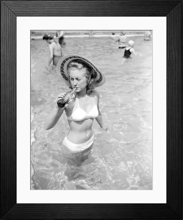 Framed Print : Woman bather cools down with a bottle of Coca Cola at the local lido. August 1952 Framed Print : Woman bather cools down with a bottle of Coca Cola at the local lido. August 1952