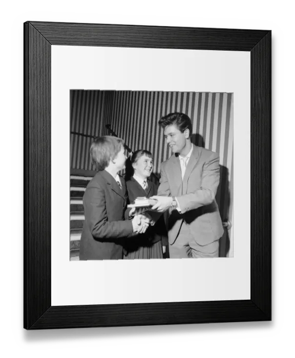 Framed Print : Singer Cliff Richard seen here presenting a school prize of three books to Carol