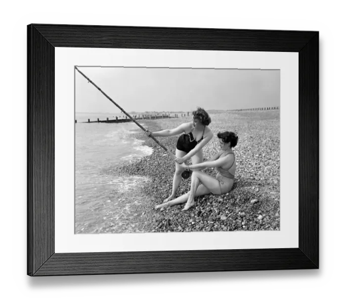 Framed Print : Two girls try a spot of fishing during a visit to the beach in Springtime Britain Framed Print : Two girls try a spot of fishing during a visit to the beach in Springtime Britain