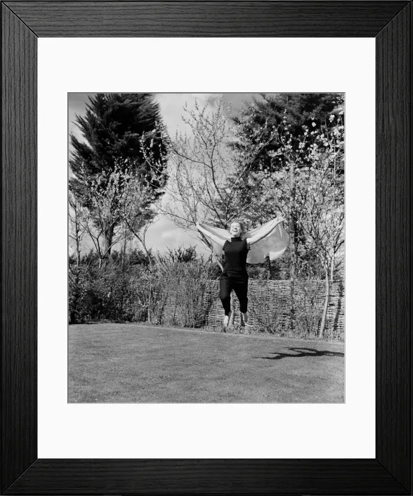 Framed Print : A woman jumping up and down in her back garden on a pleasant Spring day Circa 1954