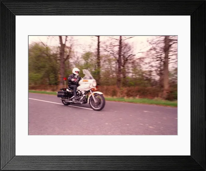 Framed Print : A police officer patrols on his Harley Davidson motorcycle Framed Print : A police officer patrols on his Harley Davidson motorcycle