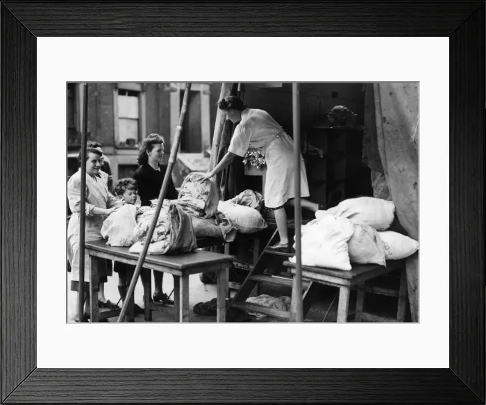 Framed Print : Women who have been bombed out of their homes receiving their clean laundry from