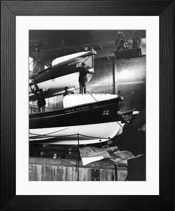 Framed Print : Lifeboats which have been damaged by coastal gales being overhauled by workmen at a