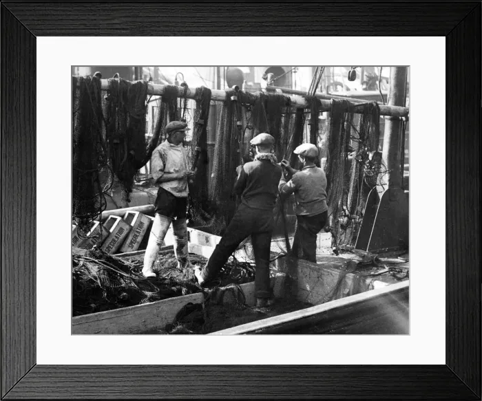 Framed Print : Fishermen mending herring nets aboard their drifter, at North Shields fish quay Framed Print : Fishermen mending herring nets aboard their drifter, at North Shields fish quay