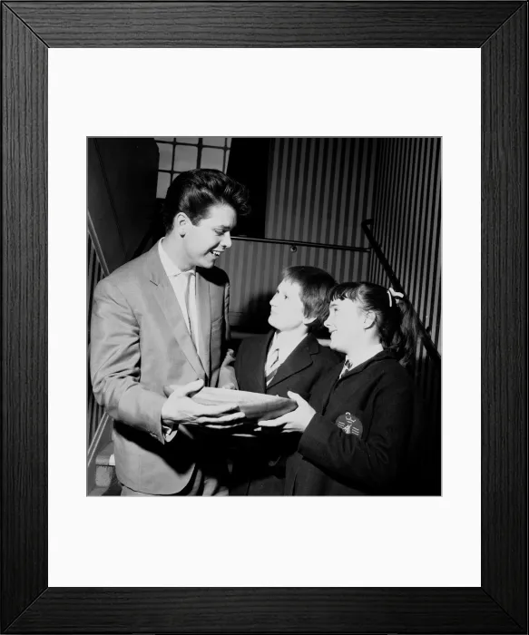 Framed Print : Singer Cliff Richard seen here presenting a school prize of three books to Carol