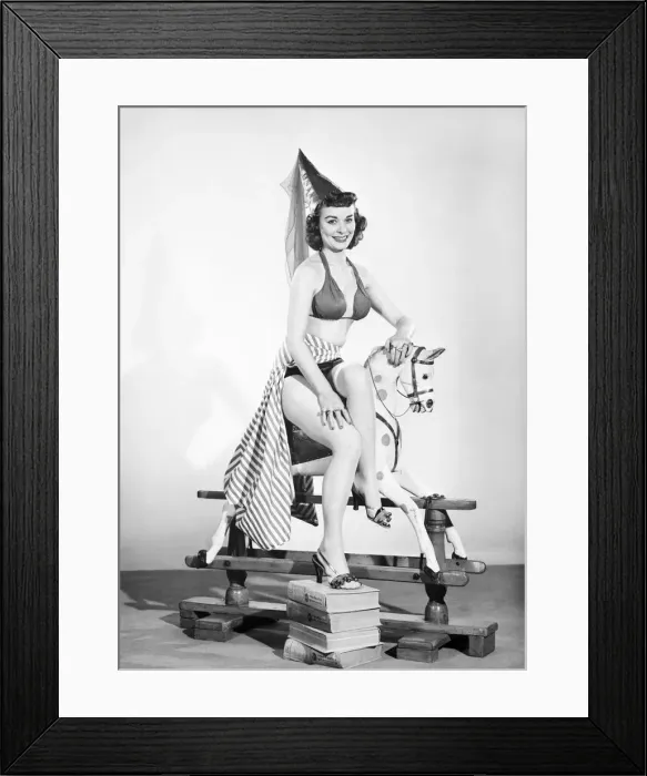 Framed Print : Model dressed as damsel. Riding rocking horse. 1965 E145-005