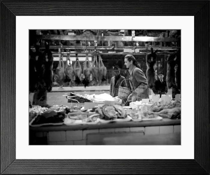 Framed Print : Woman pictured pushing pram as she passes by a butchers shop window March 1952