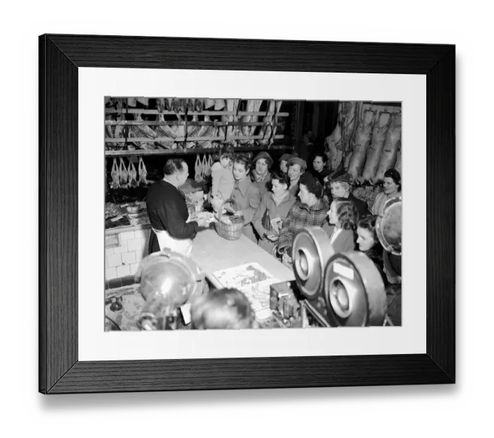 Framed Print : Film production company, filming a scene in a butchers shop as customers wait in long