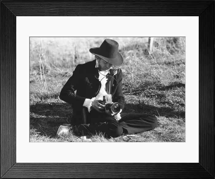 Framed Print : Rolling Stones: Mick Jagger taking pictures with his camera as he sits on the side of