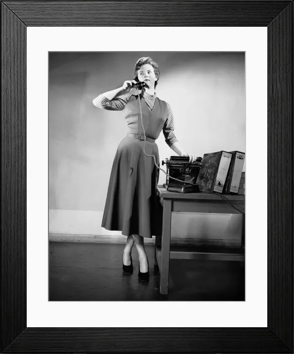 Framed Print : A secretary talking on the telephone in the office. June 1952 Framed Print : A secretary talking on the telephone in the office. June 1952