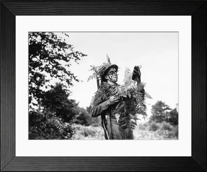 Framed Print : Fieldcraft school student examines himself in glass to admire his camouflage during