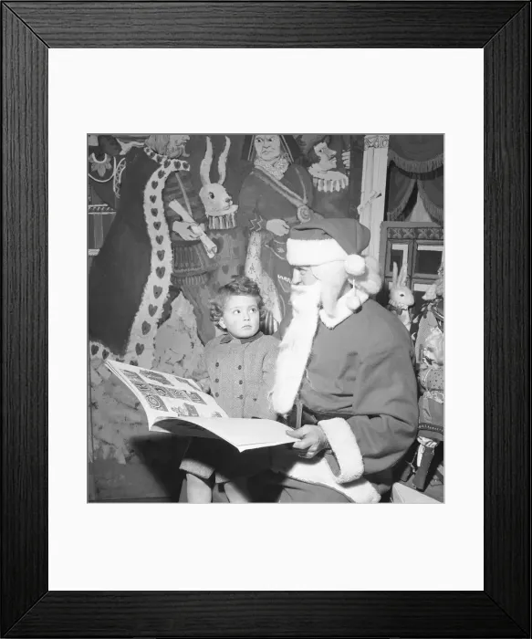 Framed Print : Father Christmas seen here checking his naughty or nice book with a young client Framed Print : Father Christmas seen here checking his naughty or nice book with a young client