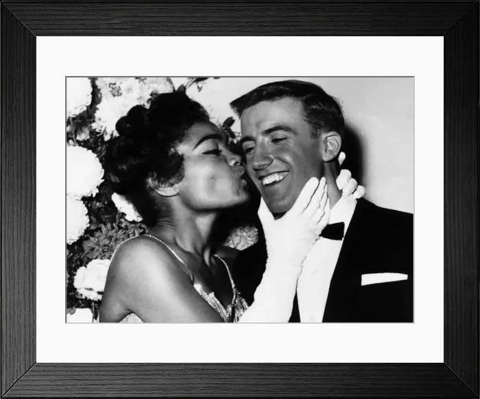 Framed Print : American actress and singer Eartha Kitt gives a kiss on the cheek to Roy Castle