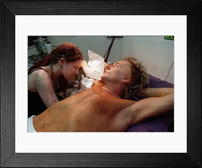 Framed Print : Rod Stewart 21st June 1999 as tattoo artsit Ronda Hoelzer decorates his arm with a