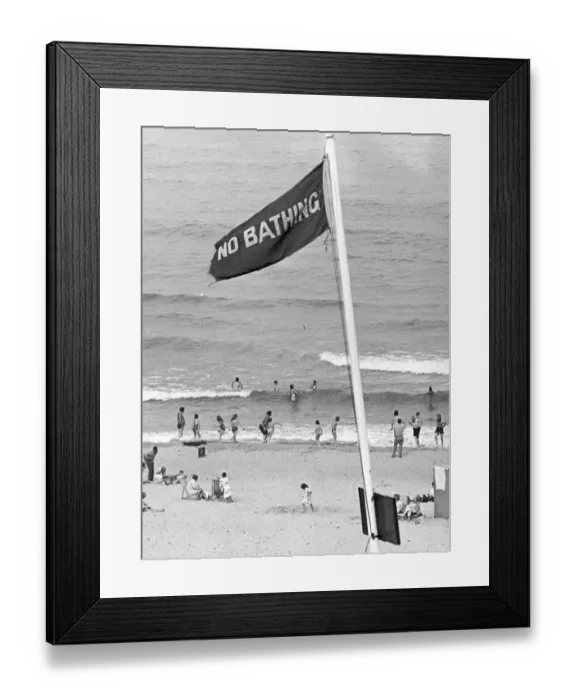 Framed Print : Holidaymakers risk their lives by ignoring the NO BATHING signs at this North East beach