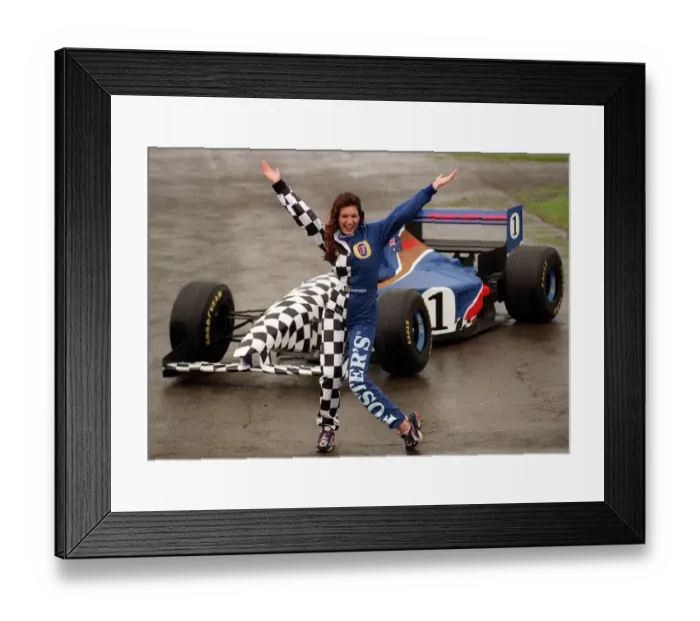 Framed Print : Coping with the wind and rain, model Kelly Brook is pictured with Fosters Formula One car Framed Print : Coping with the wind and rain, model Kelly Brook is pictured with Fosters Formula One car