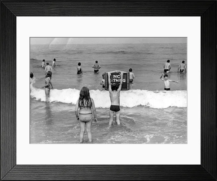 Framed Print : Holidaymakers risk their lives by ignoring the NO BATHING signs at this North East beach