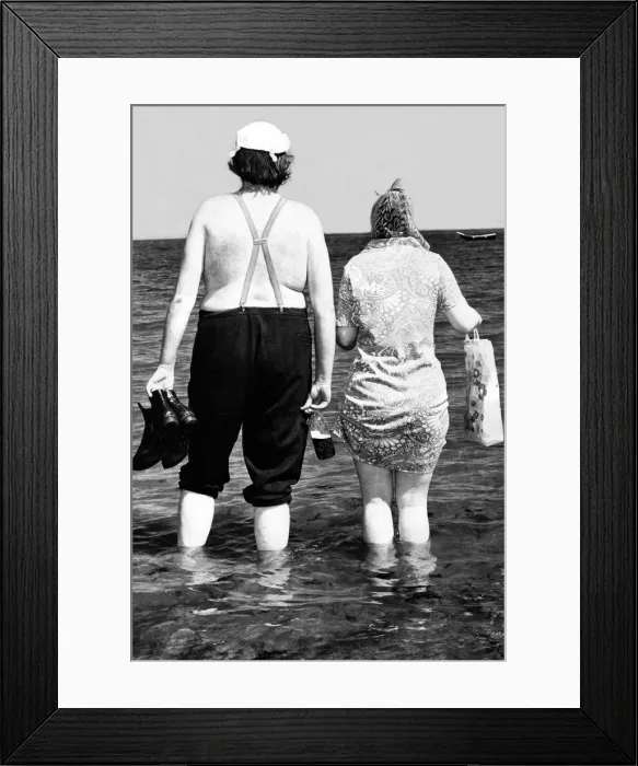 Framed Print : Typical Geordie couple Bill and Effie walk in the sea - Bill has his bottle of Brown Ale Framed Print : Typical Geordie couple Bill and Effie walk in the sea - Bill has his bottle of Brown Ale