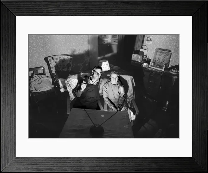 Framed Print : A evening in for a husband and wife watching a coin-operated television Framed Print : A evening in for a husband and wife watching a coin-operated television