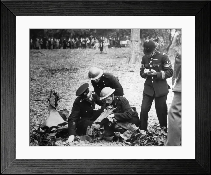 Framed Print : A fireman reading the wording on the remains of a bomb to a police officer who takes