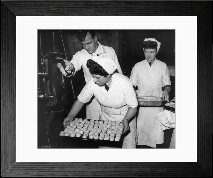 Framed Print : Women baking Swiss Rolls and sultana puddings, put their desserts into the oven during