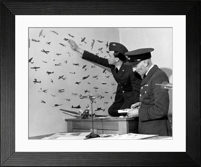 Framed Print : An RAF officer preparing cut outs of enemy planes from magazines to stick on the walls of