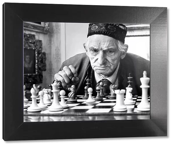 An old gentleman studying a chess board