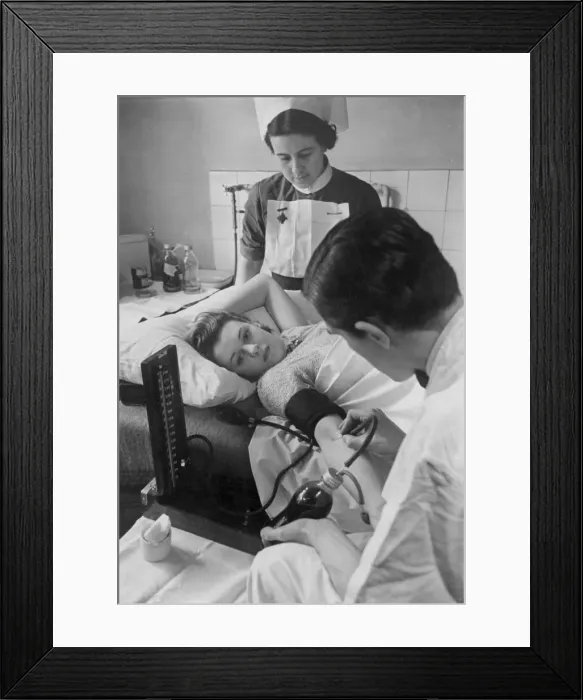 Framed Print : A woman giving blood at her doctors surgery during the Second World War as a nurse