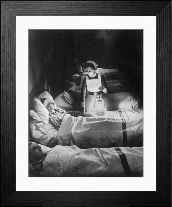 Framed Print : A nurse holiding a lamp as she visits patients on a ward at Westminster hospital
