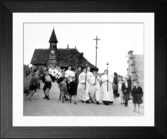 Framed Print : The procession make their way past the Clock Tower down to the beach