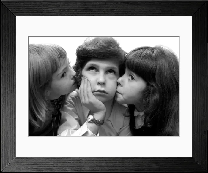 Framed Print : Leap year spells trouble for single males. Unhappy boy gets kisses and cuddles from girls Framed Print : Leap year spells trouble for single males. Unhappy boy gets kisses and cuddles from girls