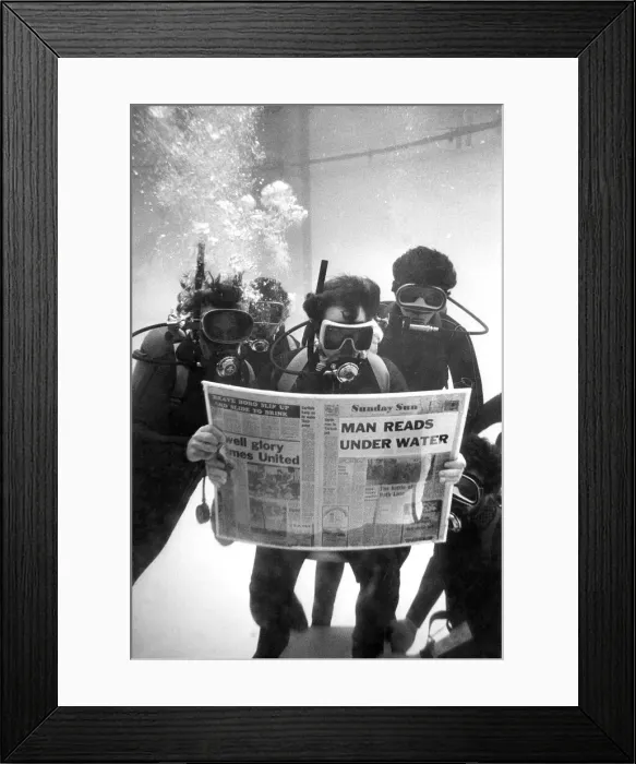 Framed Print : Divers while away some time reading their local newspaper on a charity dive Framed Print : Divers while away some time reading their local newspaper on a charity dive