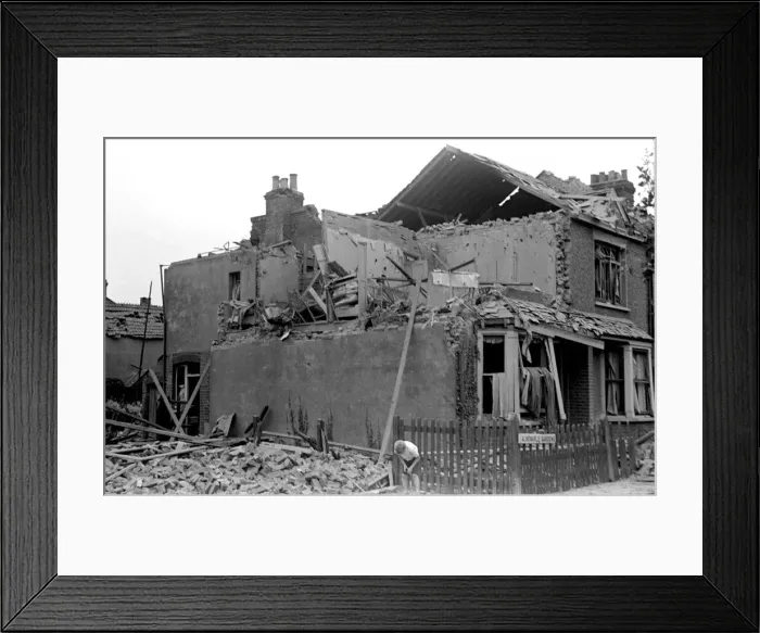 Framed Print : Alfieri. Air raid damage at Malden, London. A young boy sifts through the rubble