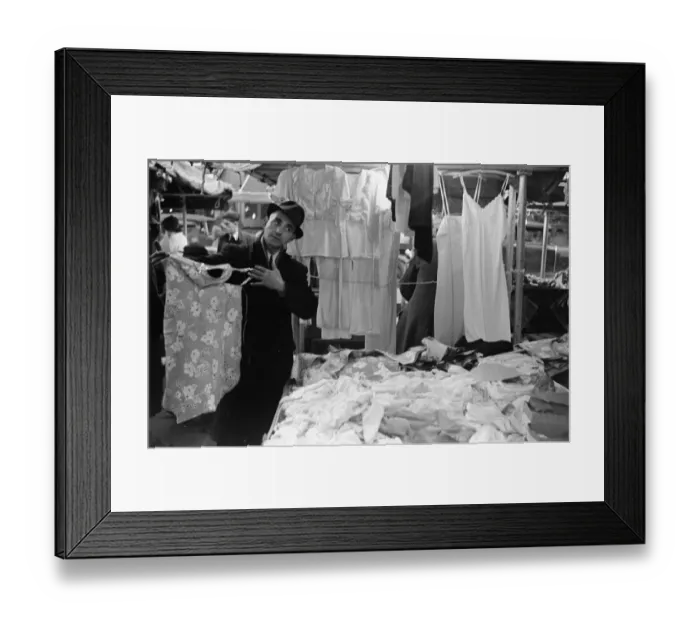 Framed Print : A market trader modelling ladies underwear to gain a sales in Kingston Market circa 1936