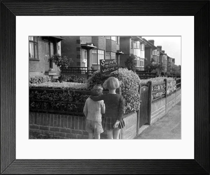 Framed Print : Young girl and boy reading an air raid shelter sign