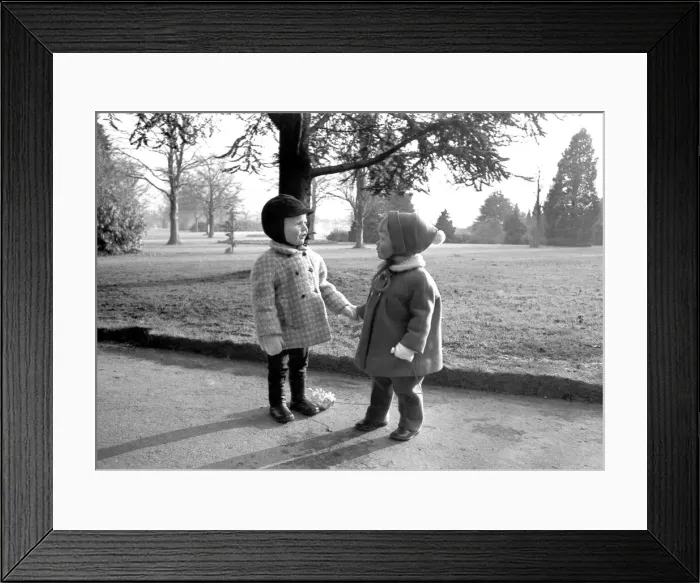Framed Print : Two toddlers holding hands and admiring each others winter attire Framed Print : Two toddlers holding hands and admiring each others winter attire